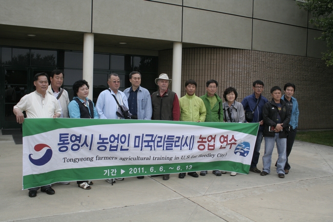 South Korean farmers pose with a banner from home at Kearney.