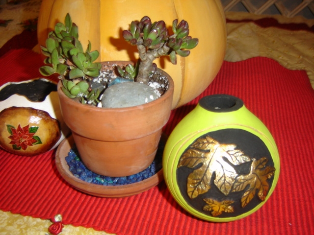Poinsettia and leaves adorn two unique gourds.