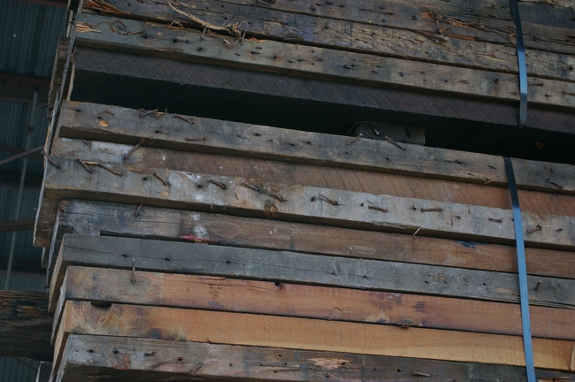 Lumber prior to processing - note the nails that all have to be removed by hand