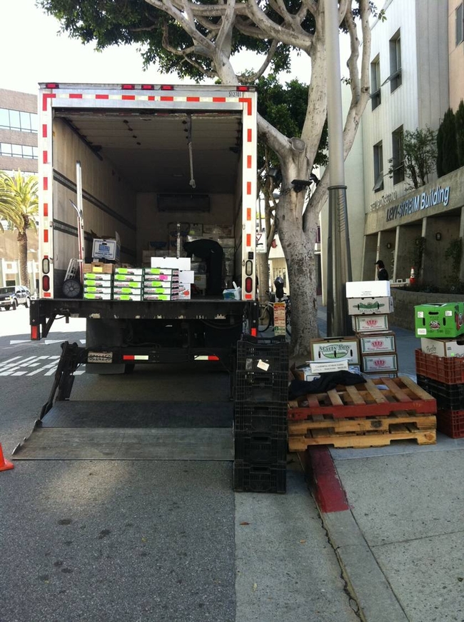 Open back-end of produce truck with crates and pallets