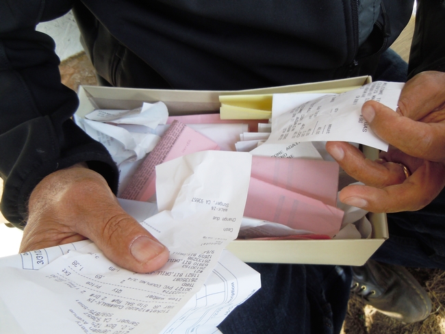 Close-up on hands holding a box of loos receipts.