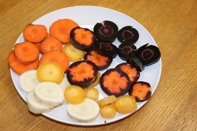 Carrots cut up on a plate, displaying patterns of coloring.